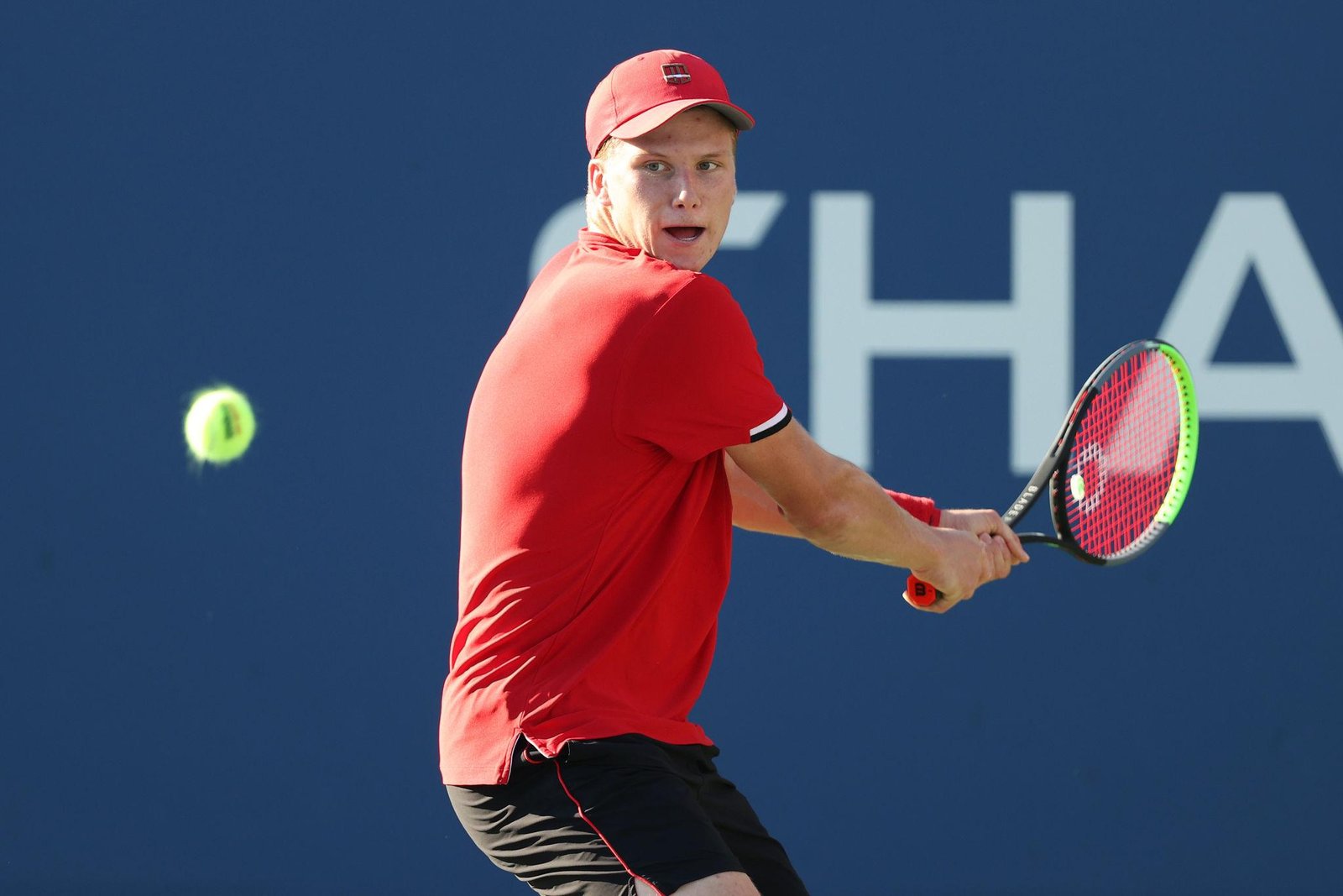 Close up of a professional tennis player demonstrating a two-handed backhand grip