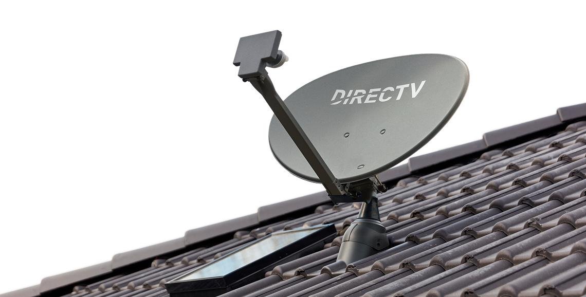 A modern satellite dish installed on a residential roof against a clear blue sky