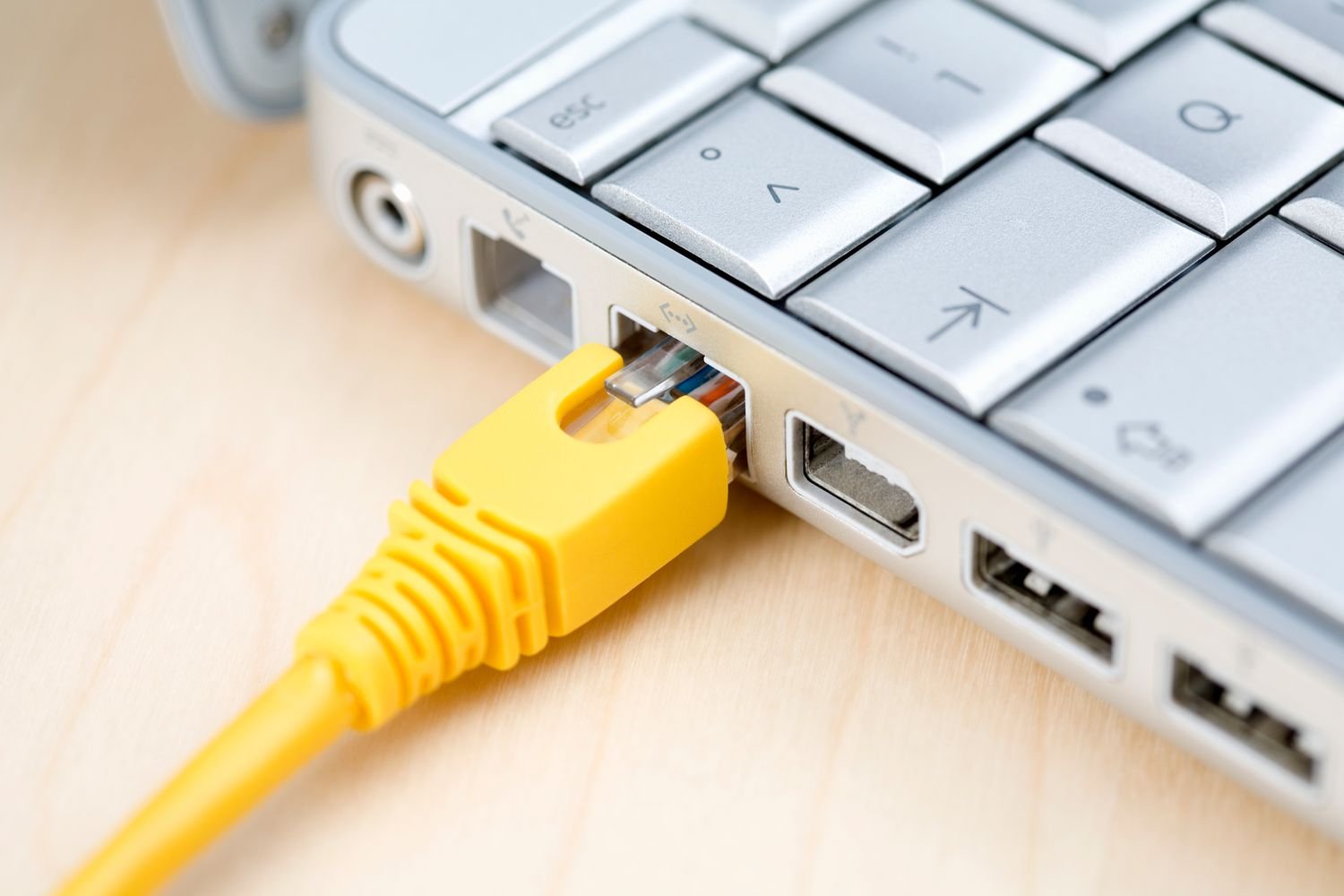 A person plugging an Ethernet cable into a device for a stable connection