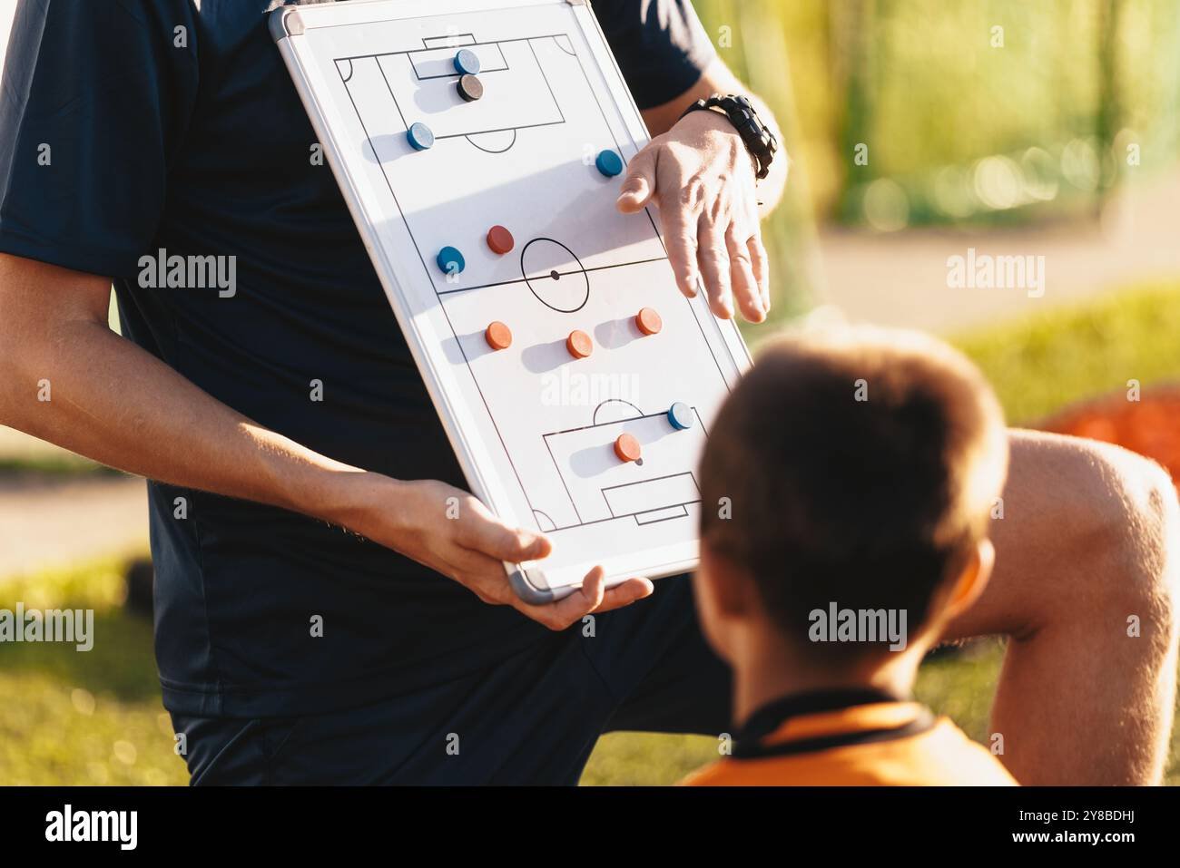 A professional coach explaining tactical positions on a board